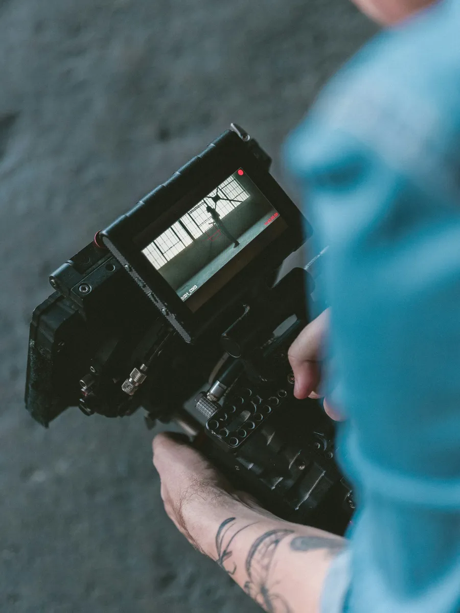 A camera operator filming a performer — Branded Films & Content Studio